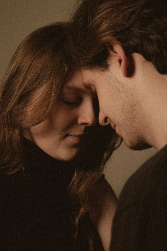 A couple standing close with their foreheads touching, eyes closed