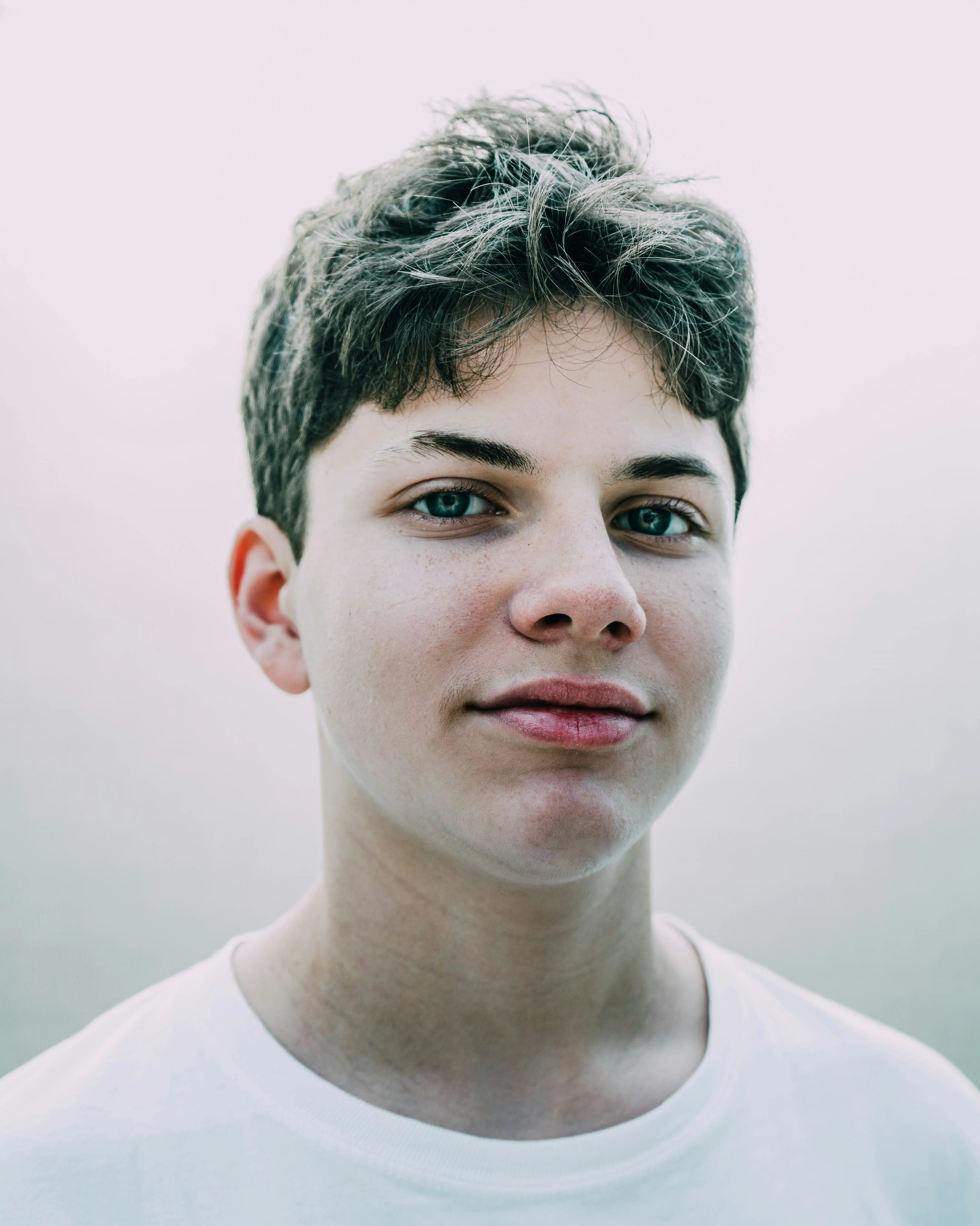 A teen boy with a calm, quiet half-smile