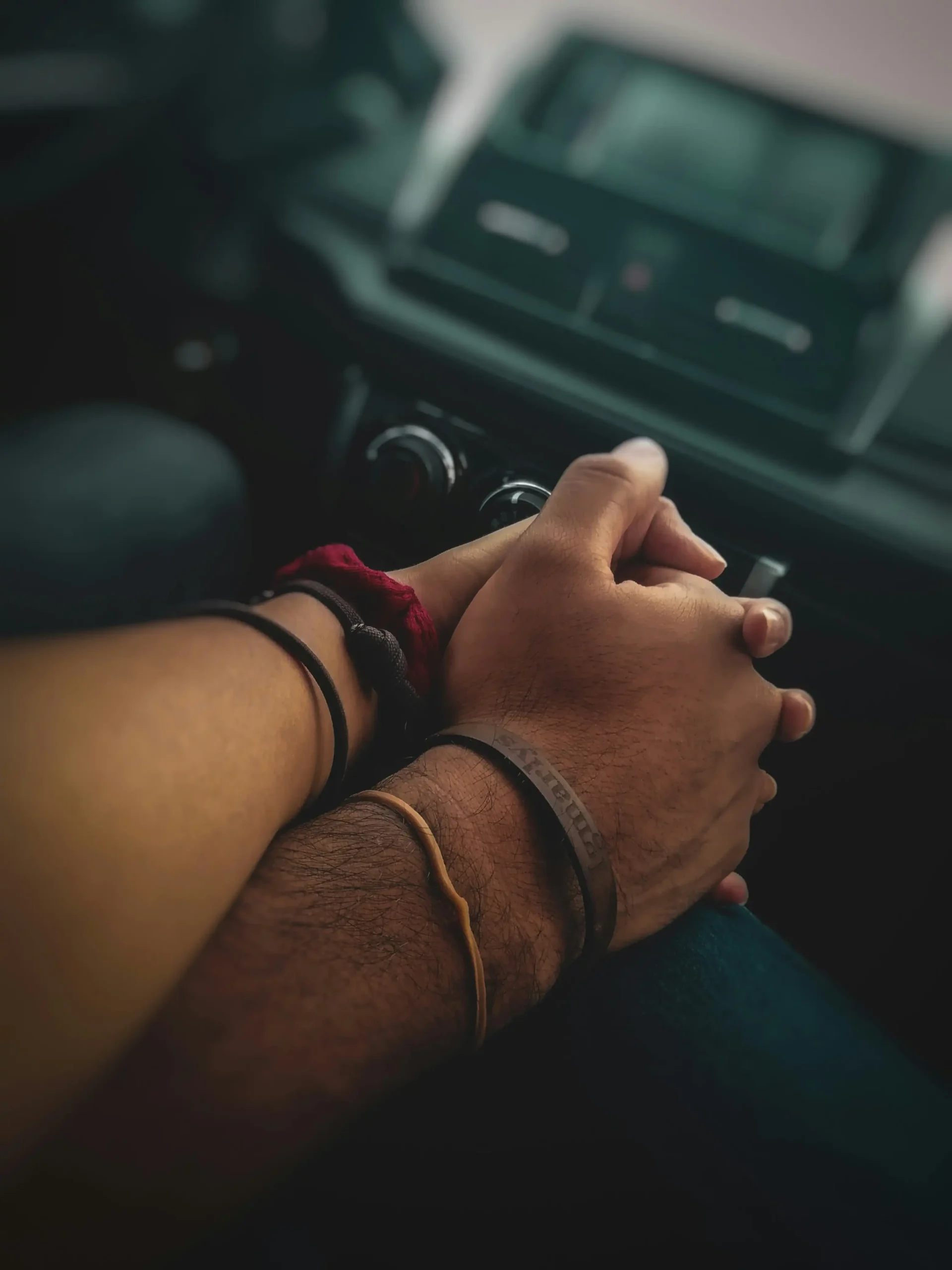 A couple holding hands together inside a car