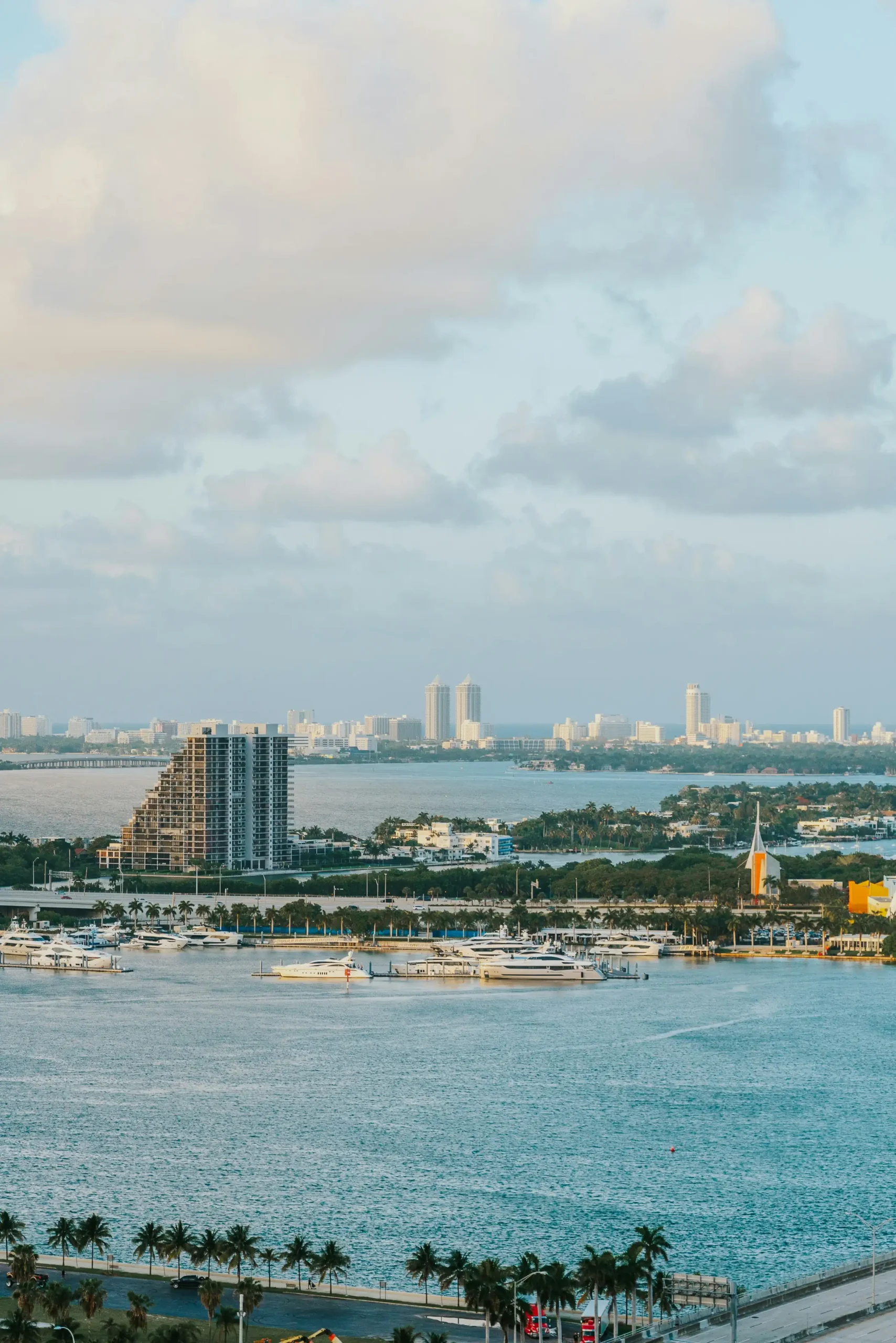 Aerial view of the Miami skyline and marina along Biscayne Bay, lined with palm trees