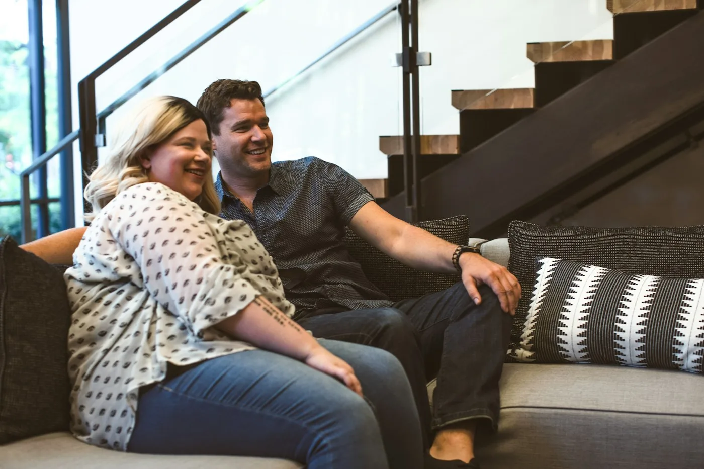 Un hombre y una mujer sentados juntos en un sofá, sonriendo