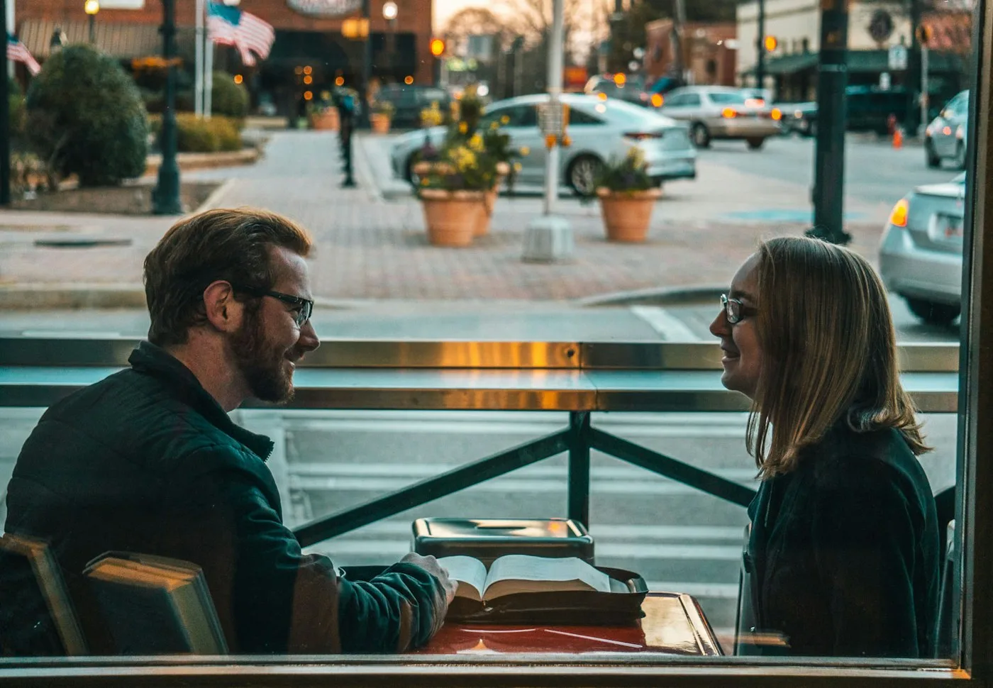 Un hombre y una mujer conversando seriamente en una mesa de café